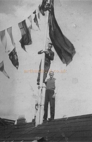 The Islington Empire is decked out with bunting and flags to celebrate the coronation of George VI in May 1937 - Courtesy Alan Towill whose father, Albert C. Towill, worked as a Maintenance Man at the Theatre at the time and is pictured up the flag pole in this photograph